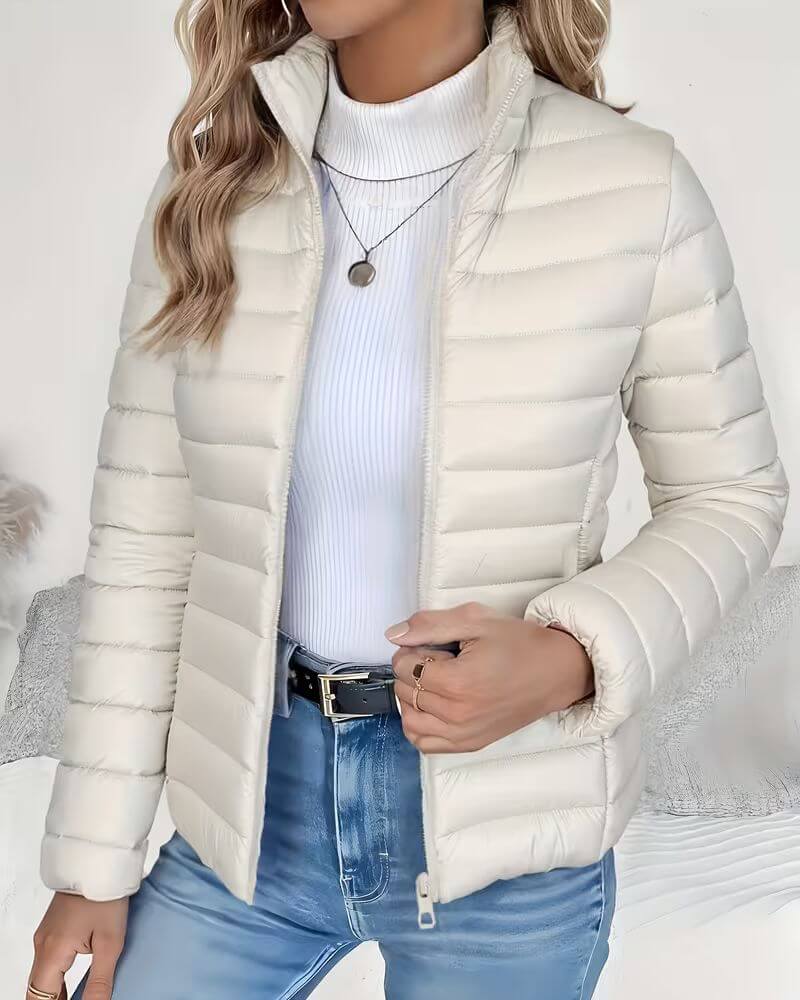 Warm women's cropped puffer jacket with a stand collar. A fashionable, lightweight quilted coat for casual wear.