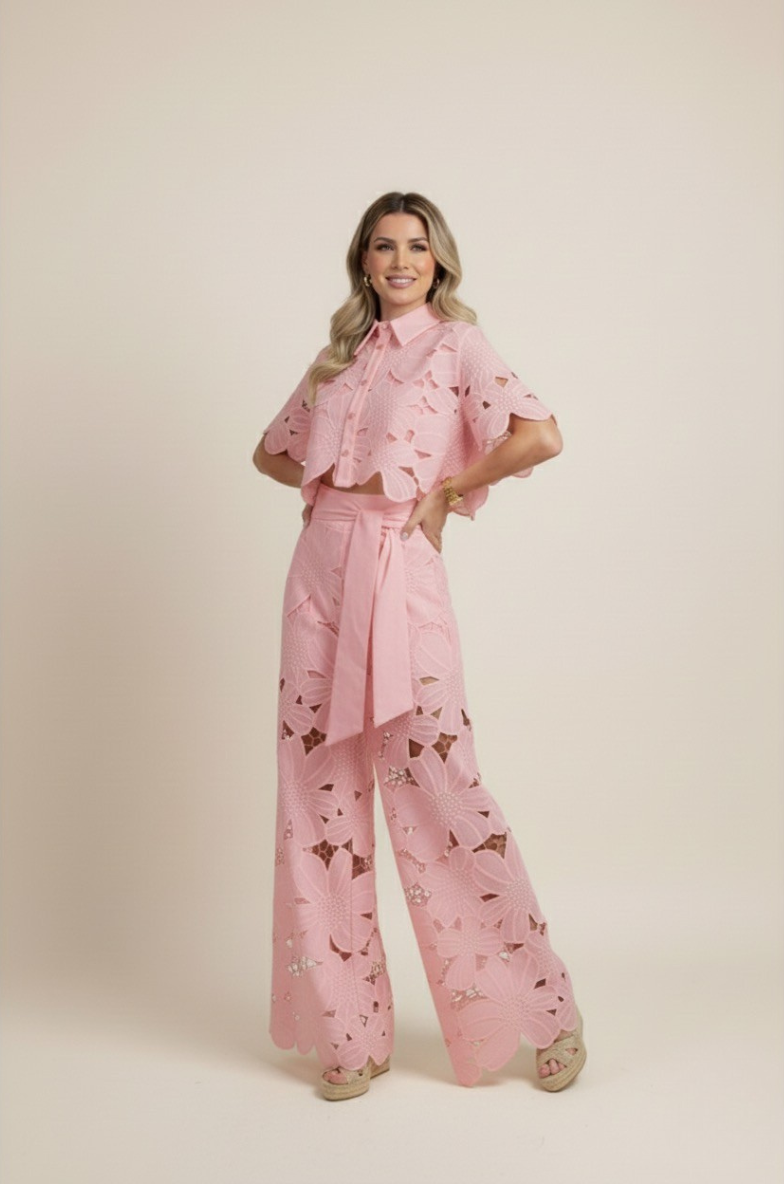 Woman models a stylish floral embroidered two-piece set with flowy wide-leg pants. Casual elegance.