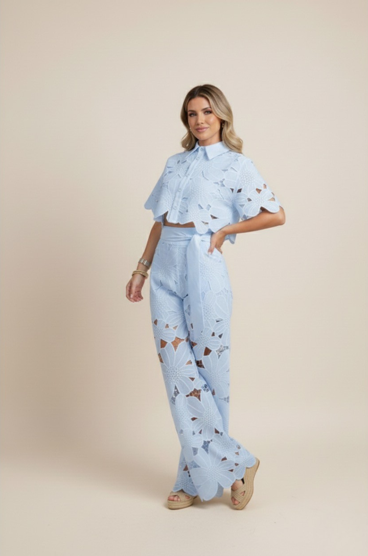 Happy woman in a chic floral embroidered two-piece wide-leg outfit. Perfect stylish co-ord for vacation.