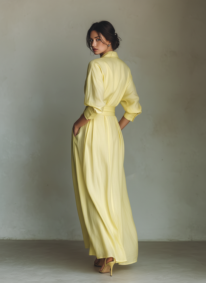 Stylish women's yellow maxi shirt dress with a tie belt, three-quarter sleeves, and V-neck, suitable for parties.