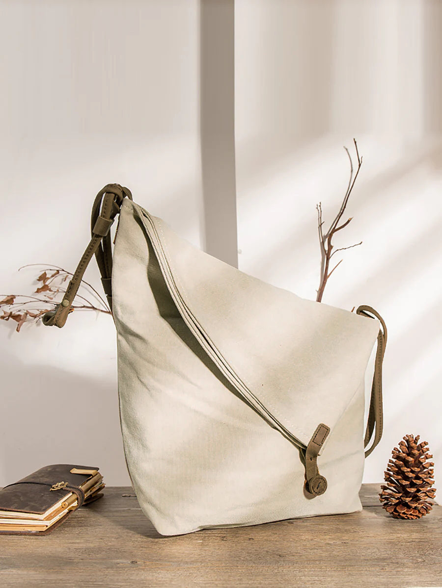 Stylish women's folded shoulder bag, a modern asymmetrical design with button closure.