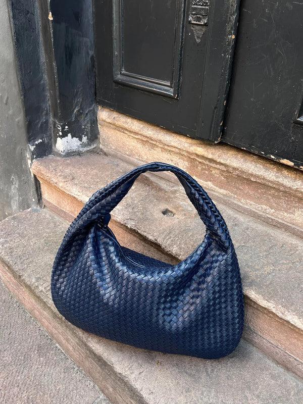 Fashionable women's vegan leather woven slouch bag, a stylish shoulder accessory.