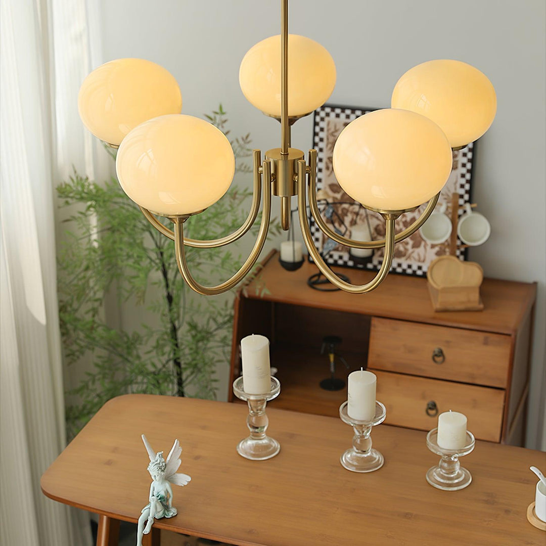 Brass glass sphere pendant lamp, provides warm ambient light for dining rooms.
