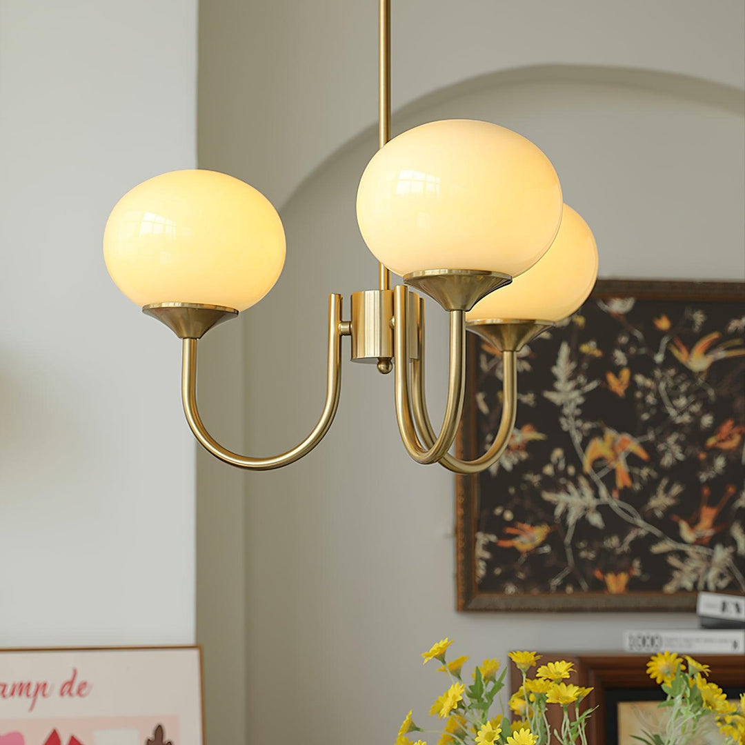 Contemporary brass sphere pendant, ambient light for refined dining experiences.
