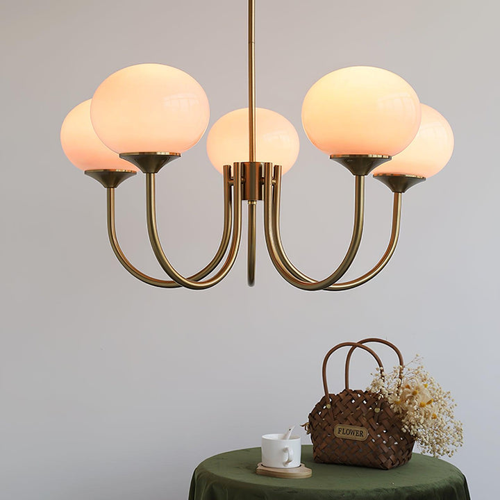 Modern brass pendant fixture, elegant glass sphere for chic kitchen decor.