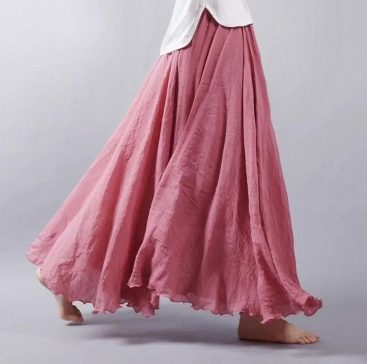 Woman in a stylish high-waisted flowy maxi skirt, showcasing its elegant drape & summer versatility.