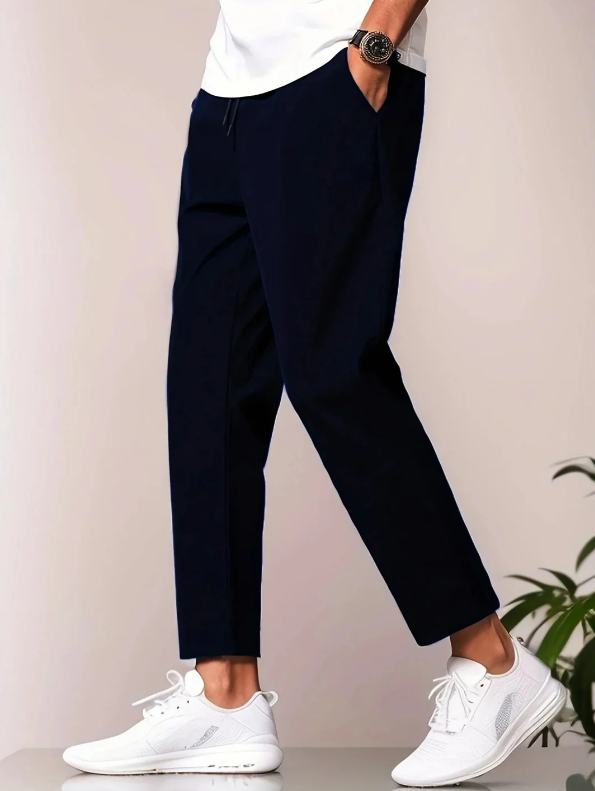 Modern fit men's casual pants, tapered design. Elastic waistband trousers offering lightweight comfort for spring wear.