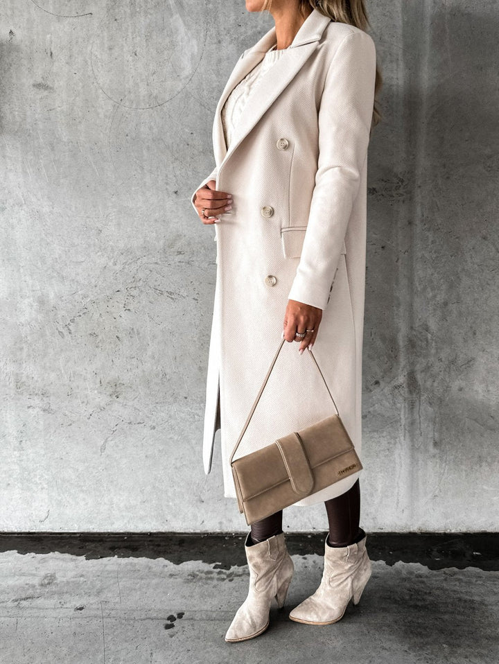 Woman wearing an elegant double-breasted winter jacket, providing warmth and style for cold days.