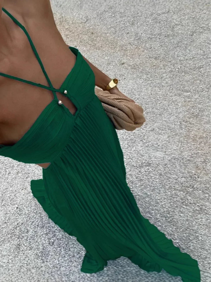 Texture shot of a women's pleated maxi dress fabric, highlighting the graceful pleats and luxurious feel.