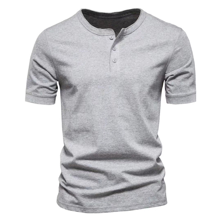 Detail shot of the button placket on a men's short sleeve Henley shirt, casual style.