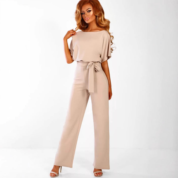 Full-length shot of a woman in a stylish wide-leg jumpsuit with a tied waist, comfortable & elegant.