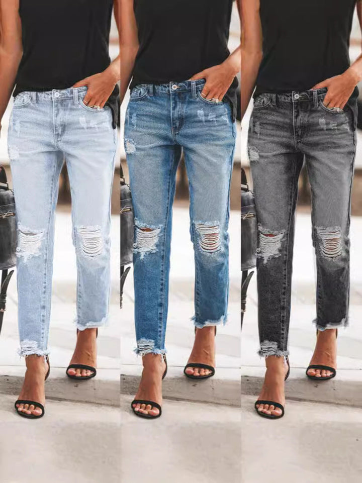 Women's casual ripped denim jeans with a stylish frayed hem. Perfect for everyday fashion and comfort.