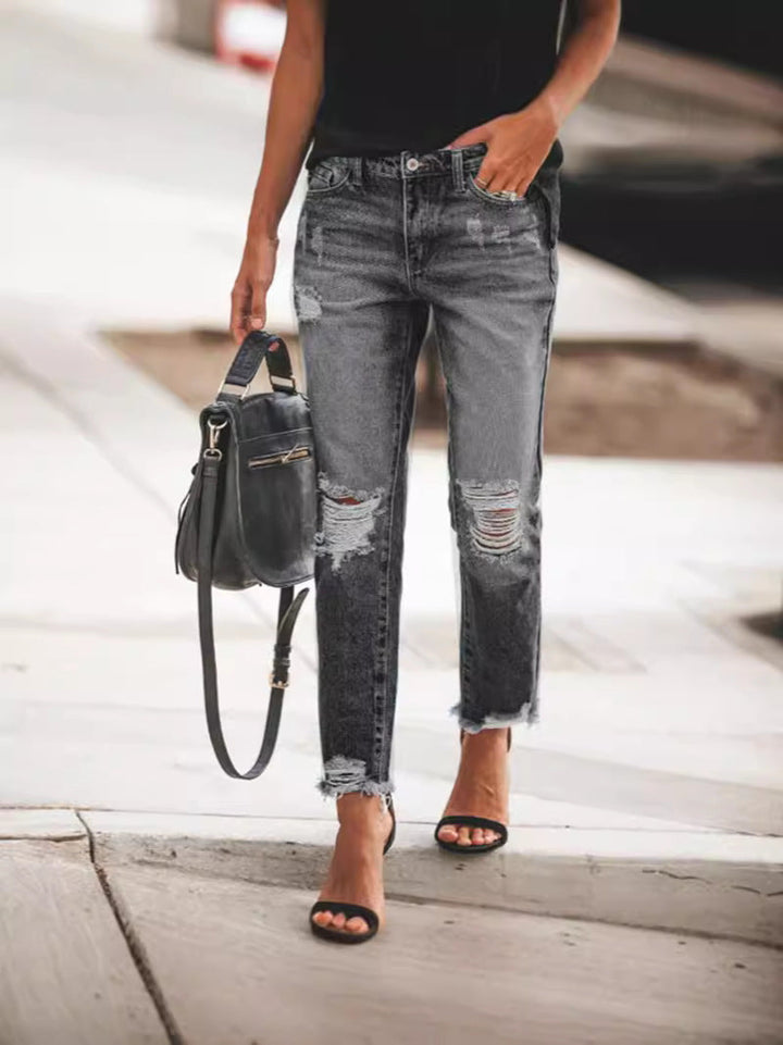 Comfortable women's casual jeans, light wash denim with cool rips and a distressed frayed hem detail.