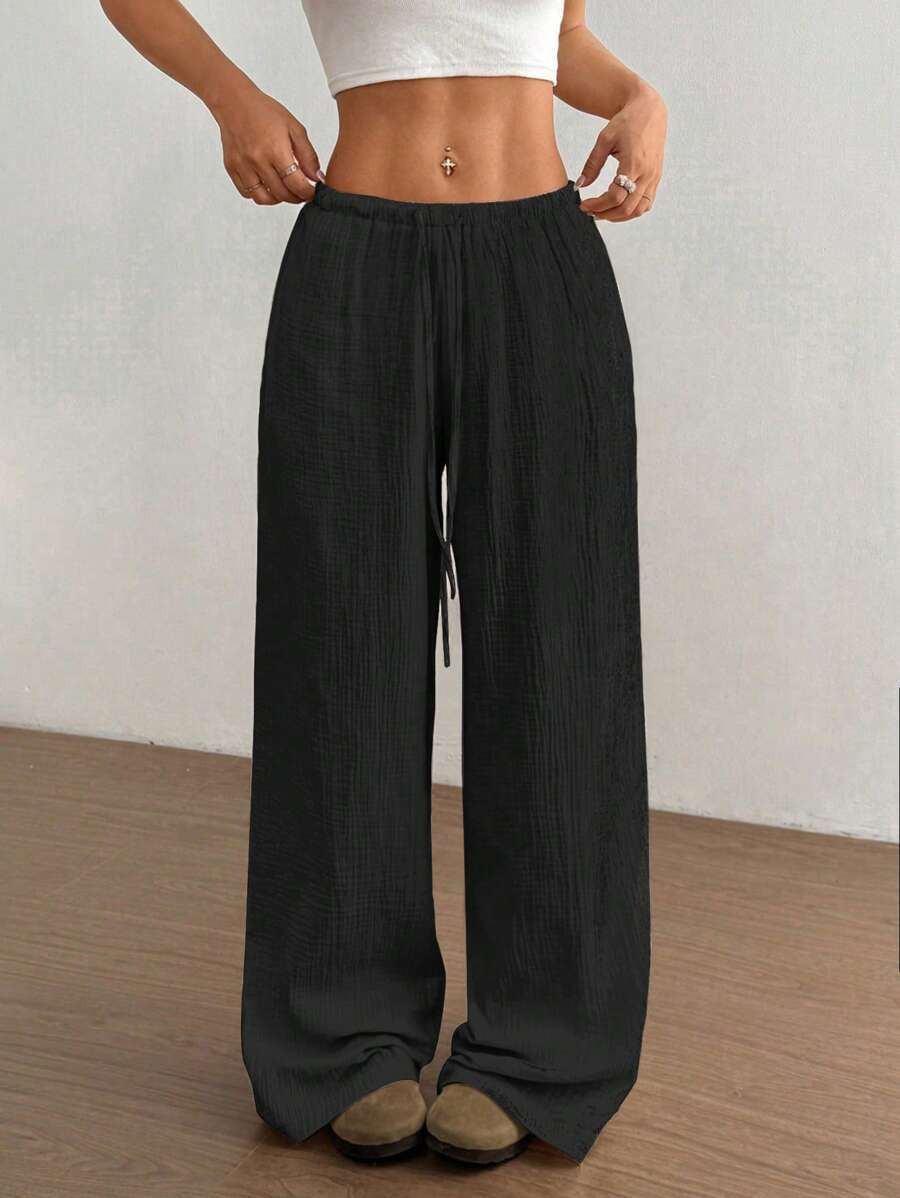 Women's wide leg flowy trousers with a drawstring waist. Comfortable, relaxed fit for casual summer fashion.