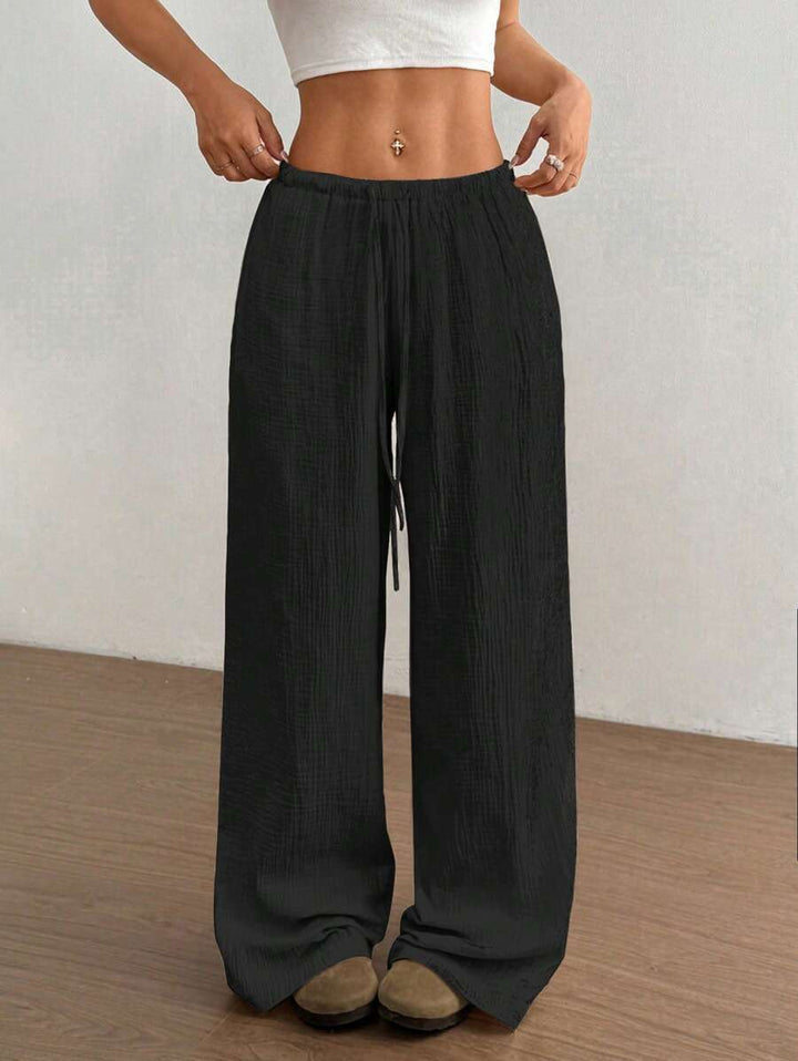 Women's wide leg flowy trousers with a drawstring waist. Comfortable, relaxed fit for casual summer fashion.