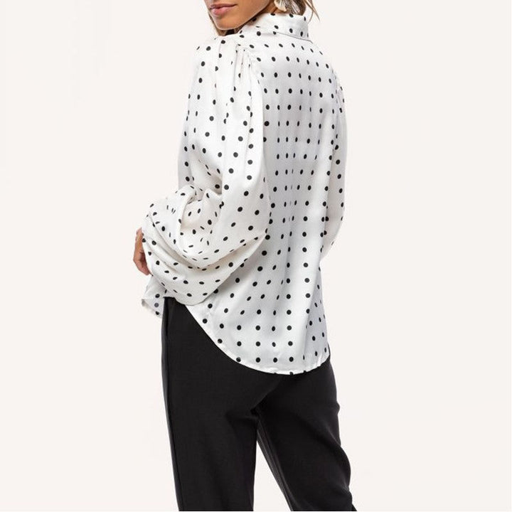 Fashionable women's long sleeve blouse featuring a polka dot print and trendy balloon sleeves. Chic and elegant top.
