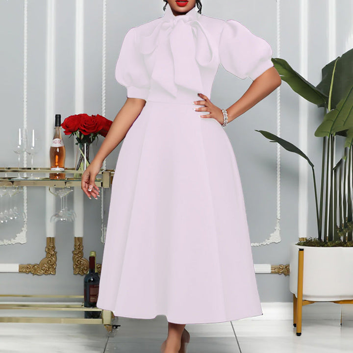Chic women's long gown featuring elegant puff sleeves & a bow neckline, ideal for special occasion or formal wear.