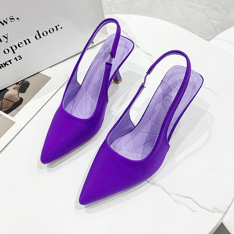 Detailed view of women's black slingback pumps, featuring a narrow pointed toe & low elegant heel.