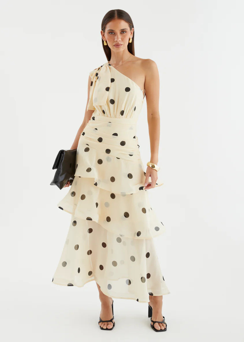 Elegant women's party maxi dress with an asymmetrical neckline, a voluminous skirt, and playful polka dots.