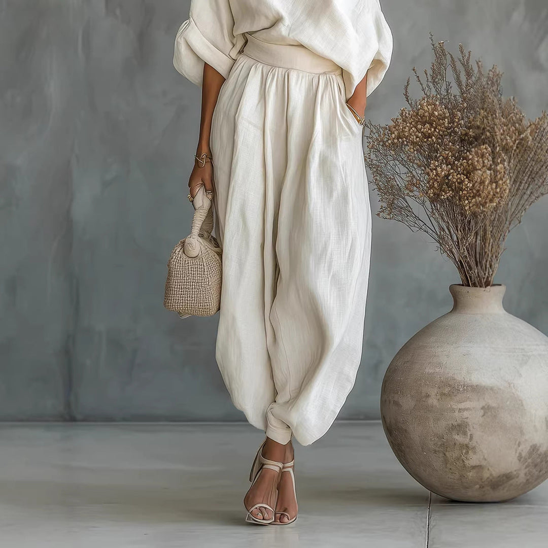 Comfortable cream women's jumpsuit featuring a chic asymmetrical neckline & loose fit, great for summer wear.