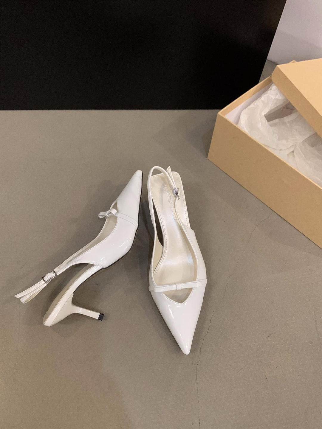 Detail: Elegant women's slingback pumps, fine ankle strap, pointed toe design. Stylish formal footwear.