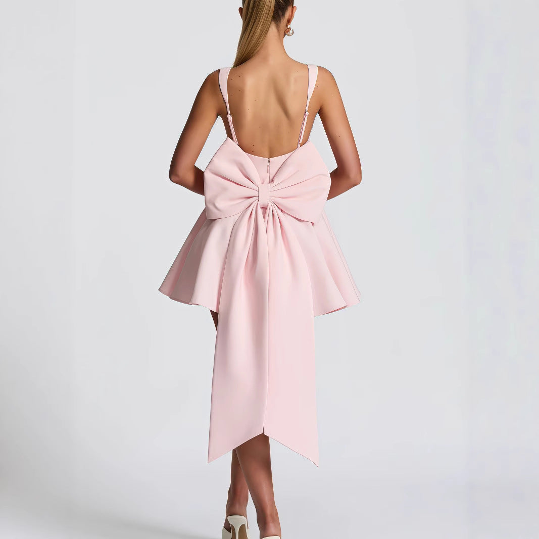 Chic women's formal dress with a prominent bow detail and elegant, flowing hemline.