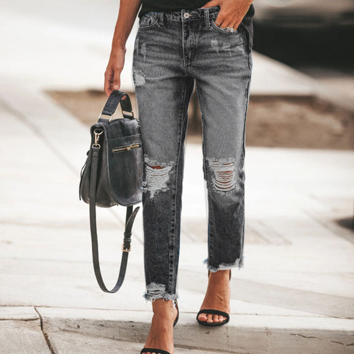 Trendy women's ripped denim jeans with a frayed hem, ideal for versatile casual styling.