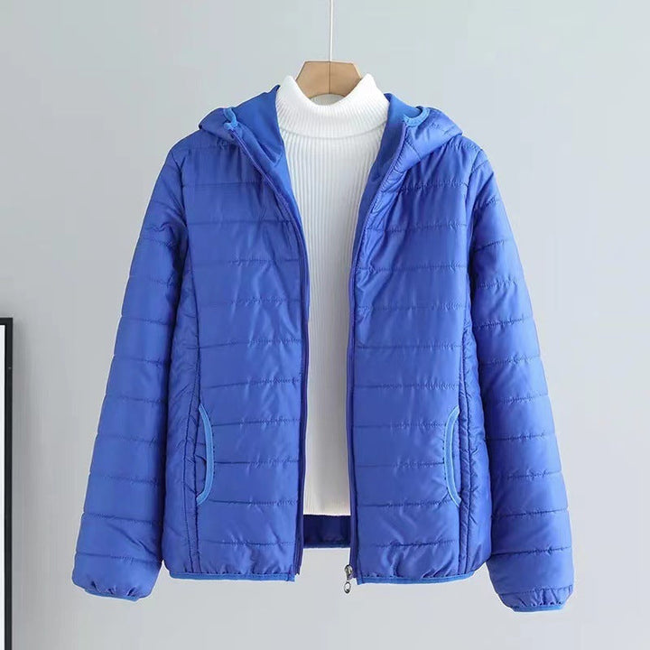 Practical women's transitional quilted jacket with ample pockets & protective hood, navy.