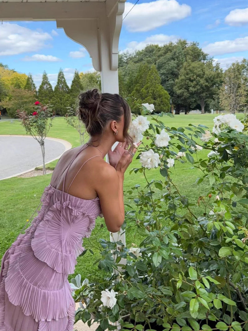 Model wearing a charming purple flowy ruffle dress, an elegant sleeveless women's occasion dress.