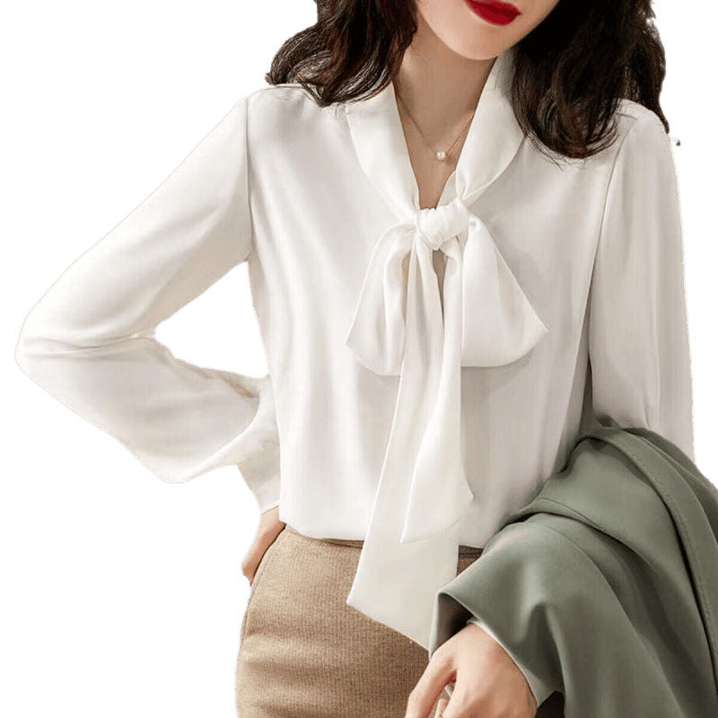 Close-up of the elegant bow detail on a women's white blouse, showcasing its chic and classic style.