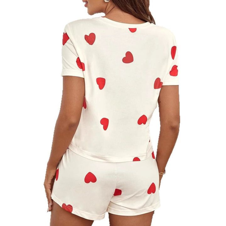 Two-piece women's heart print loungewear set in cream. Includes long-sleeve top and matching pants for comfort.