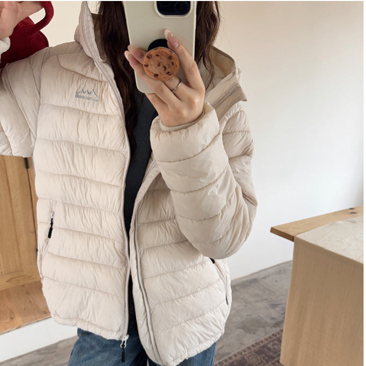 Quilted women's puffer jacket with full zip & removable hood, a versatile fall & winter coat.