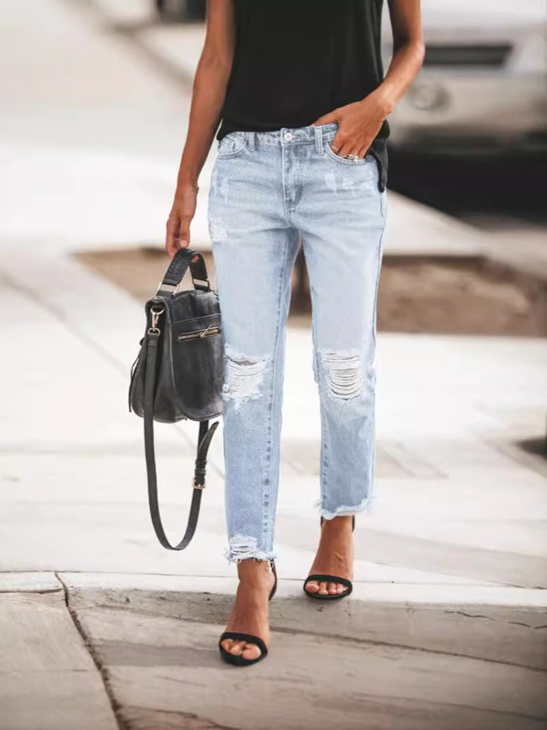 Stylish women's ripped jeans, classic blue denim with a fashionable frayed hem. Versatile for casual outfits.