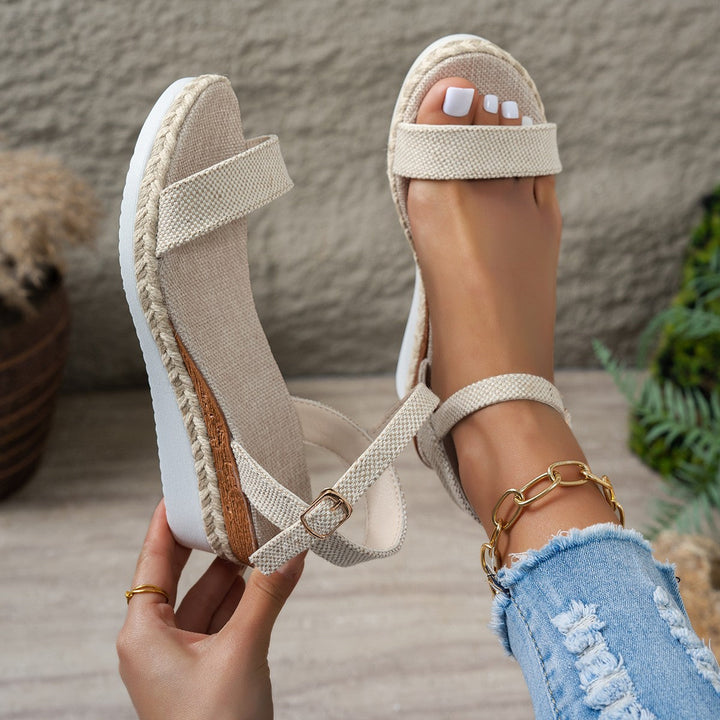 Chic women's beige wedge sandals with elegant strap, woven accents & espadrille heel. Versatile summer footwear.