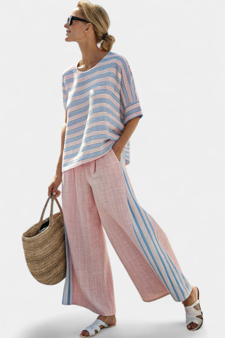 Woman wearing elegant striped two-piece set, blouse & wide-leg pants, ideal for summer resort or vacation.