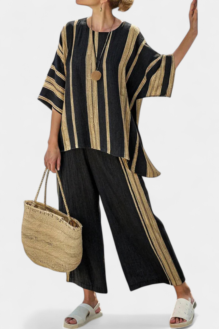 Woman in comfortable oversized multi-colored striped top & relaxed wide-leg pants set, ideal for summer casual.