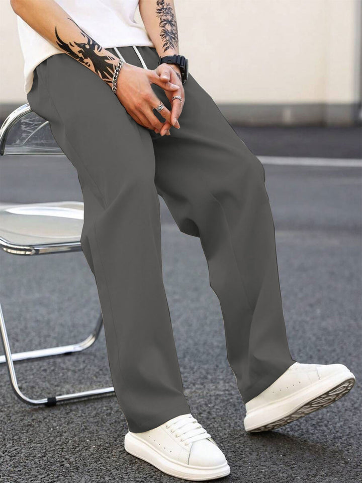 Grey men's loose fit leisure pants with elastic waist, front view. Casual & comfortable everyday wear.