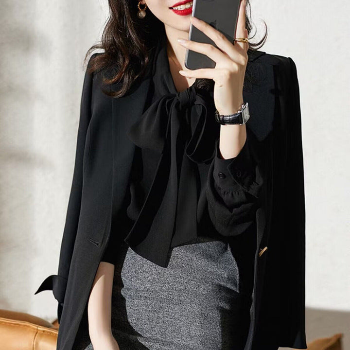 Stylish long-sleeve black blouse featuring a chic bow, perfect for a sophisticated office or casual look.