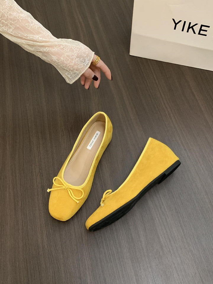 Delicate bow detail on elegant women's ballerinas, comfortable flat slip-on shoes.