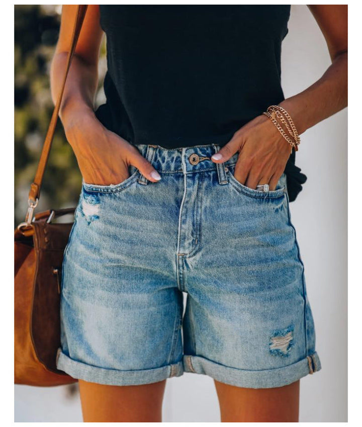 Comfortable women's casual denim shorts in light blue, featuring trendy distressed details & rolled hem.