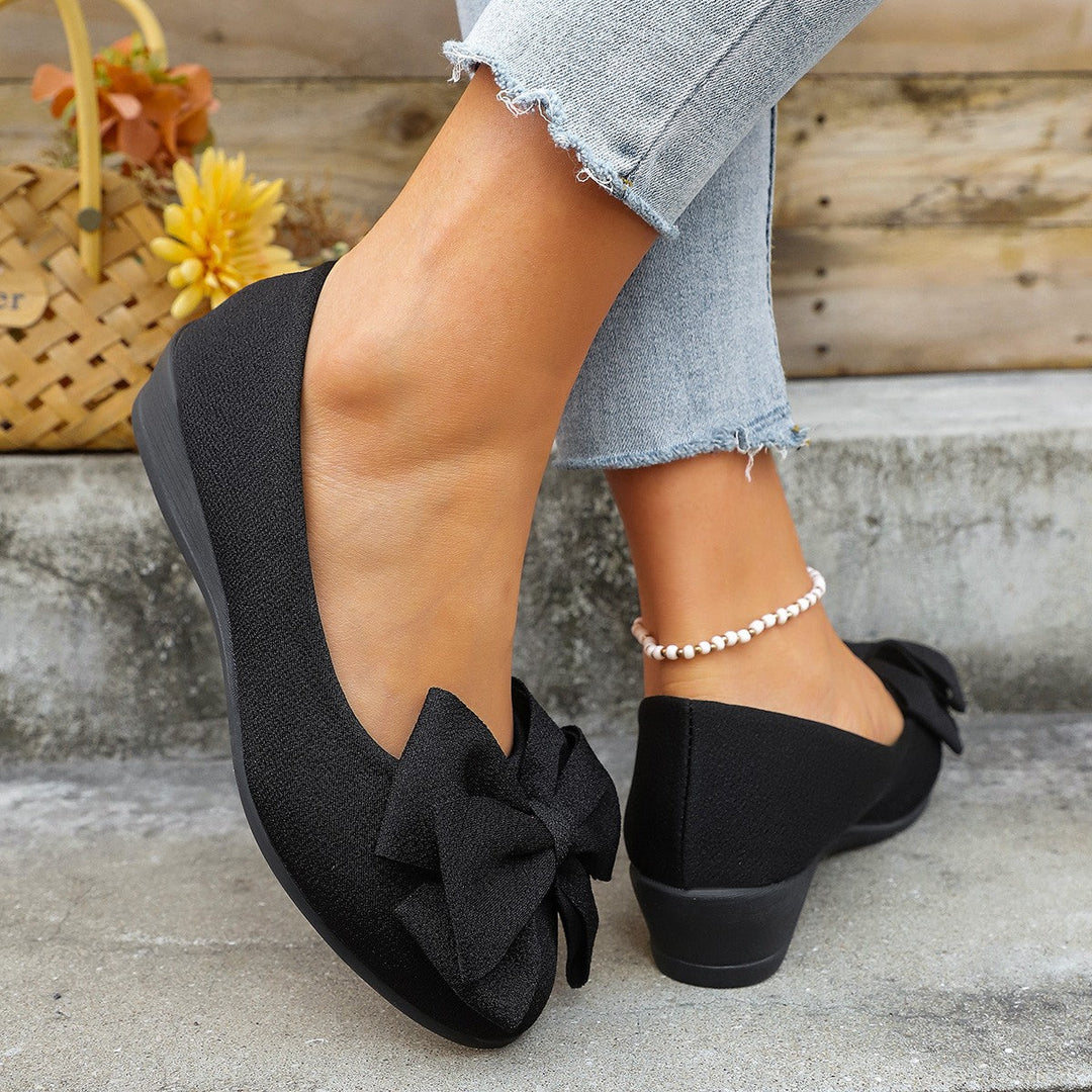 Women's chic black ballet flats with delicate bow, perfect for elegant everyday wear.