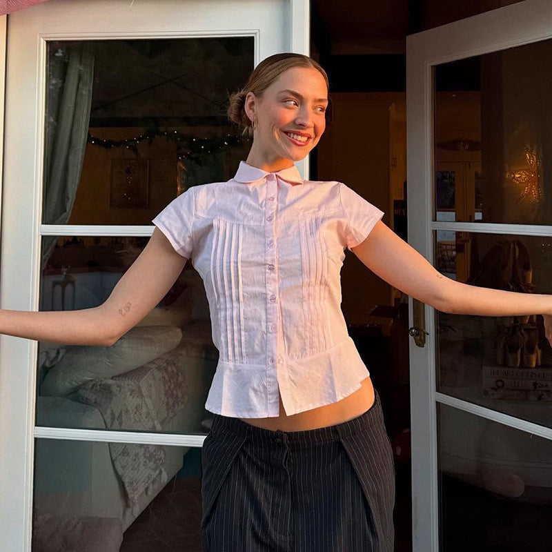 Trendy women's short sleeve blouse with unique button accents, suitable for office or casual spring outfits.