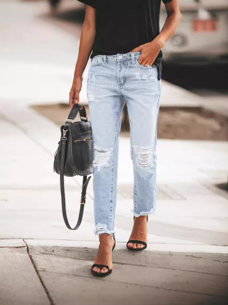 Everyday fashion women's blue denim jeans, ripped details and a unique frayed hem. Stylish bottoms.