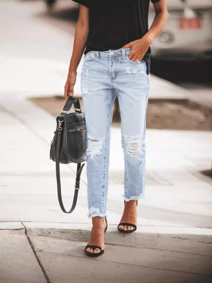 Everyday fashion women's blue denim jeans, ripped details and a unique frayed hem. Stylish bottoms.