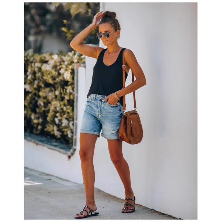 Fashionable women's light blue denim shorts, distressed and comfortable, with a stylish rolled-up hem.