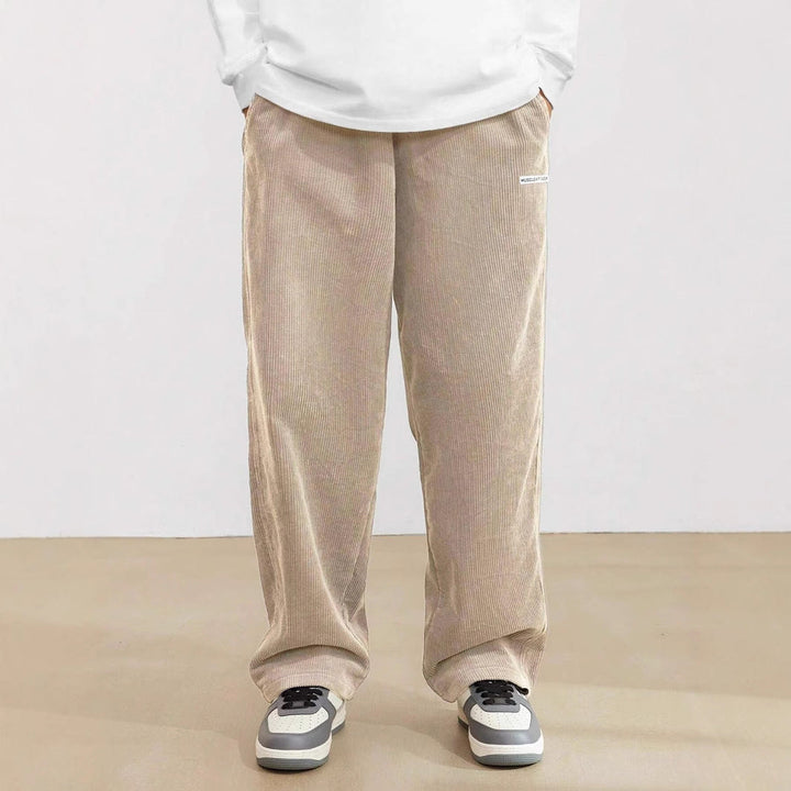 Men's loose fit wide leg pants featuring an elastic waistband & side pockets. Modern, comfortable style.