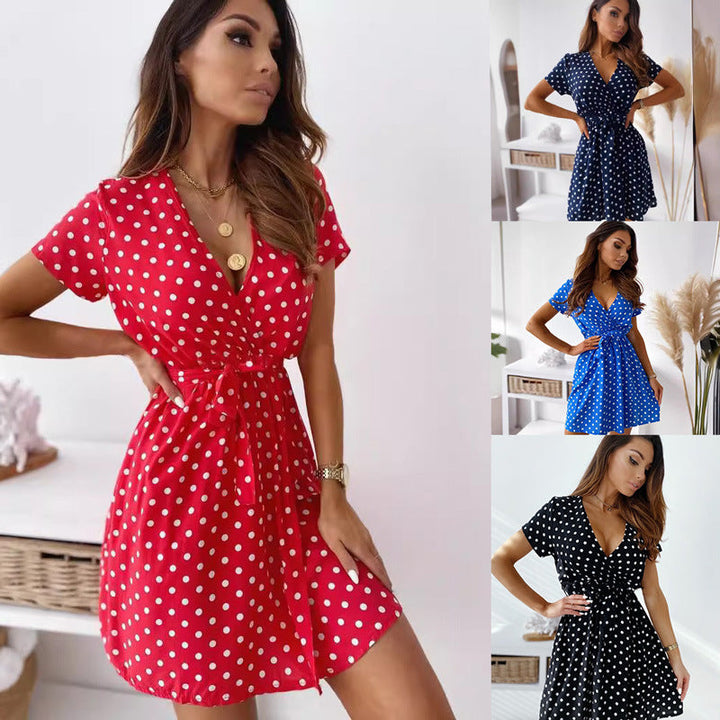 Women's playful black & white polka dot mini wrap dress with V-neck & short sleeves, perfect for summer casual wear.