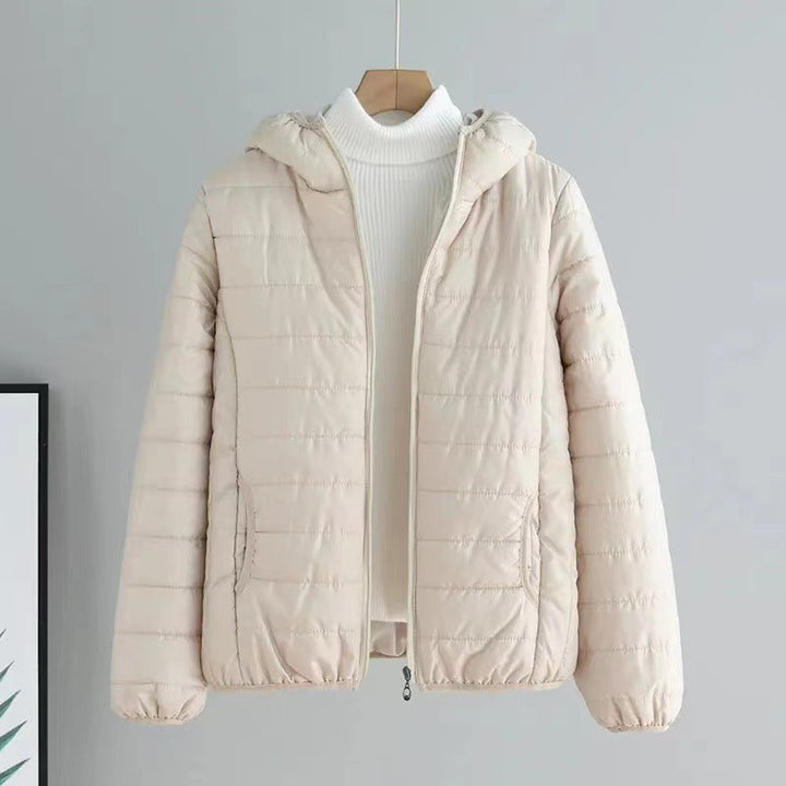 Close-up of the quilted pattern on a women's transitional jacket in a dark color.