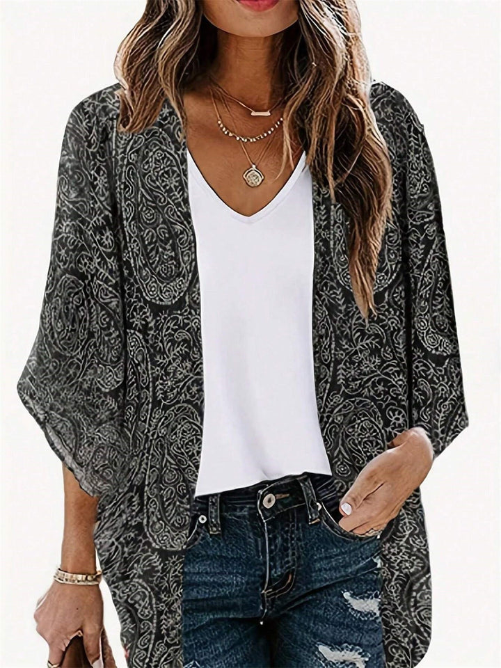 Fashionable women's kimono jacket in black with an intricate pattern, offering a comfortable, elegant fit.