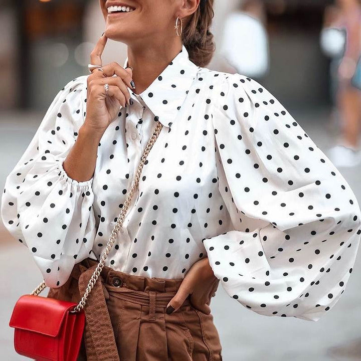 Women's chic polka dot blouse with elegant balloon sleeves. Fashionable long sleeve top for versatile wear.